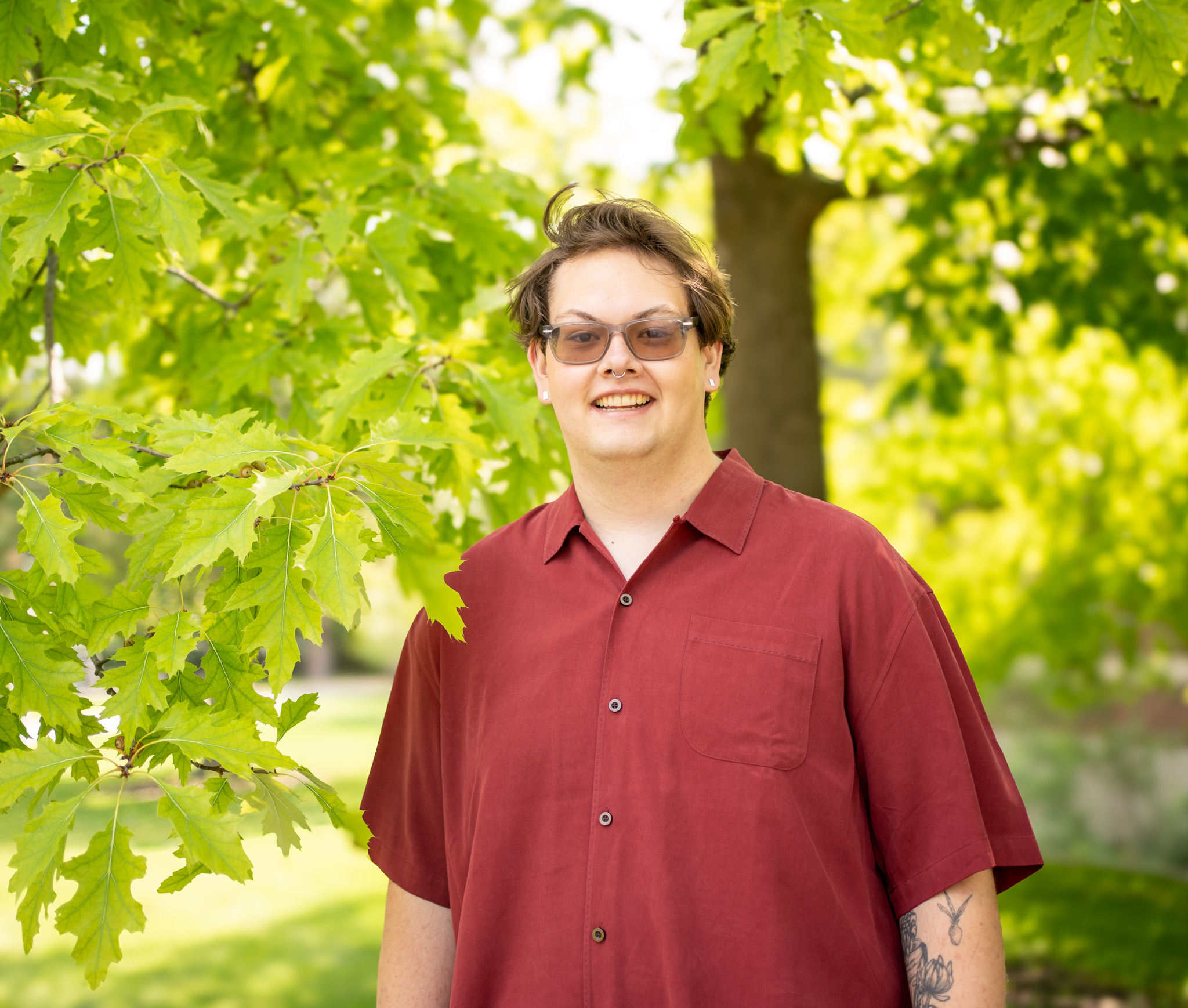 Jayce Beck smiling next to an oak tree